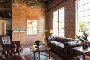 8Q2A4077 The Parlor at Ice House on Main features elegant Chesterfield furnishings and exposed brick, bringing warmth to any event.